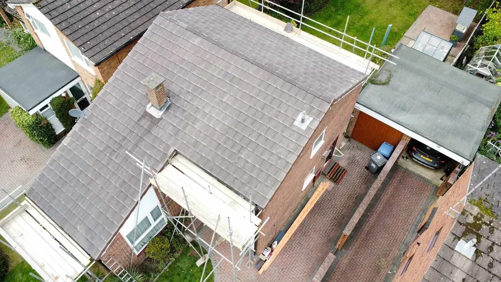 Aerial view of a grey roof beside a driveway and garage