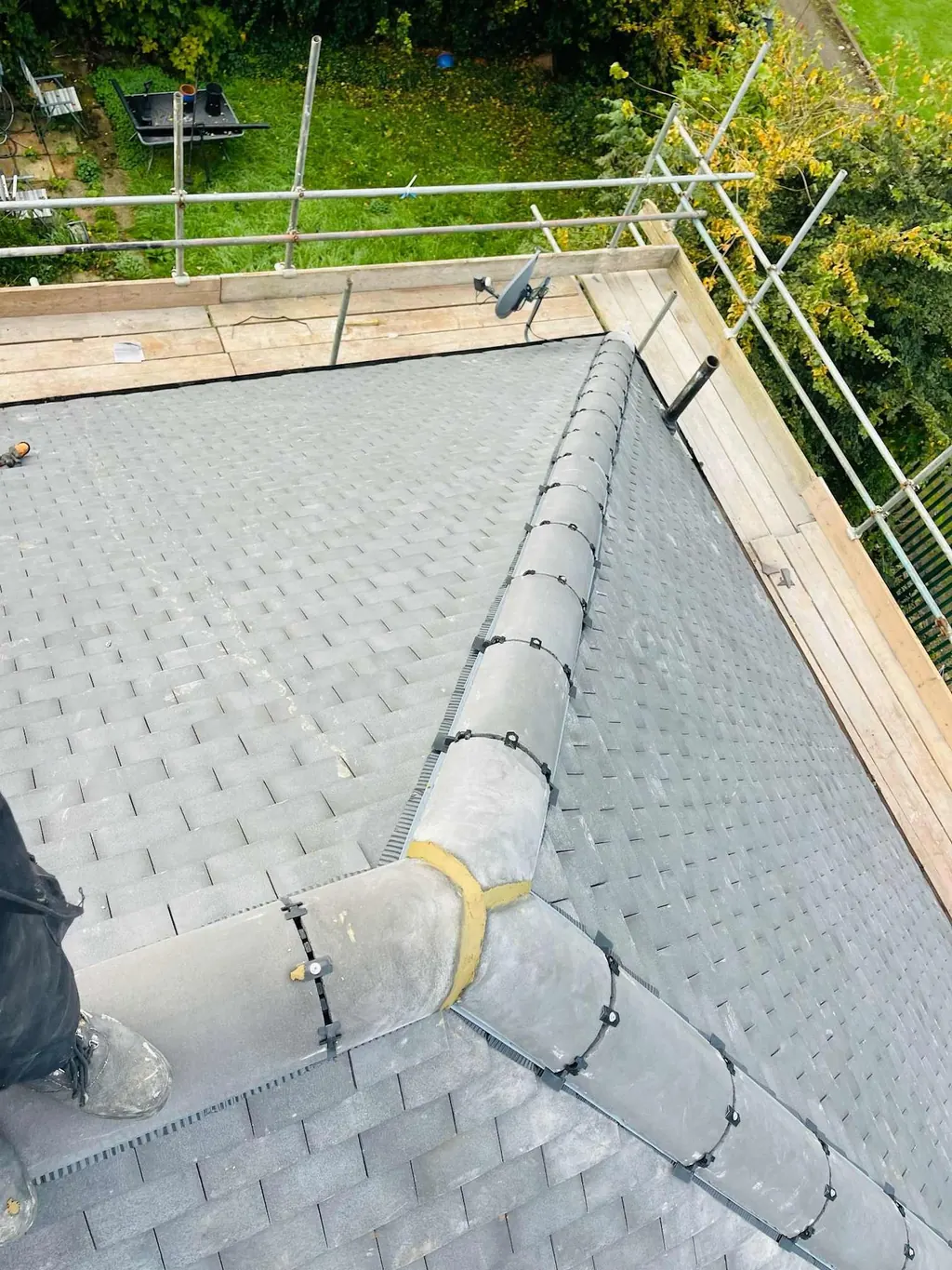Grey ridge and hip tiles meeting at a roof junction