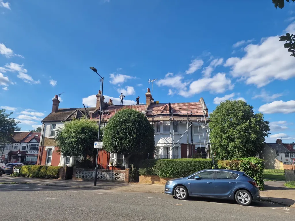 Scaffolded gabled houses viewed across a street
